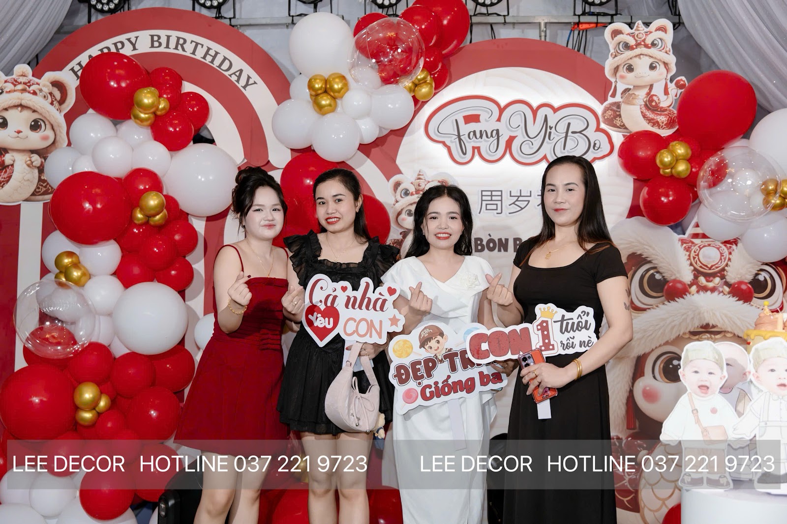 Khu chụp ảnh gia đình tại tiệc thôi nôi phong tục người Hoa ở Bình Dương — backdrop khổ lớn, standee chibi và phụ kiện cầm tay do Lee Decor 247 thực hiện