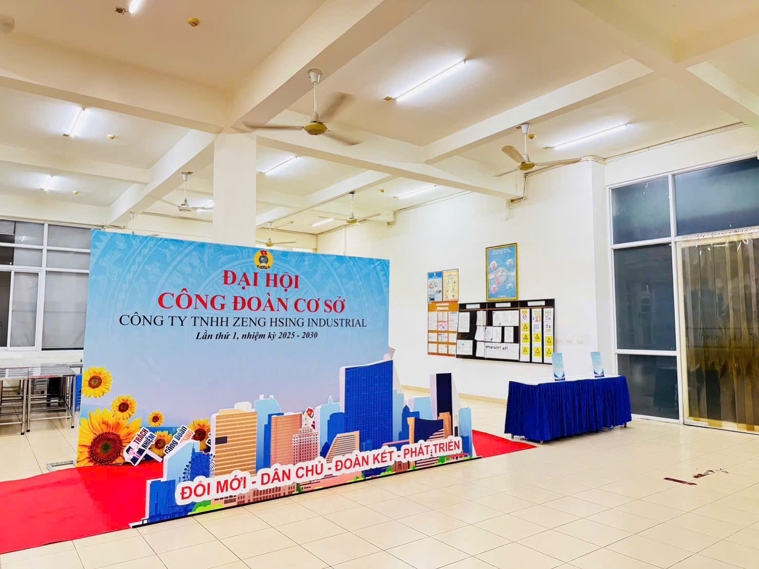 Trang trí hội trường tiệc cuối năm và đại hội công ty tại nhà máy Bình Dương — sân khấu, phông chính và bàn ghế phủ áo do Lee Decor 247 thi công